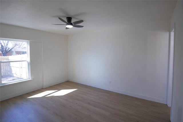 spare room featuring ceiling fan, wood finished floors, and baseboards