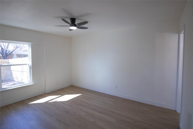 spare room with ceiling fan, baseboards, and wood finished floors