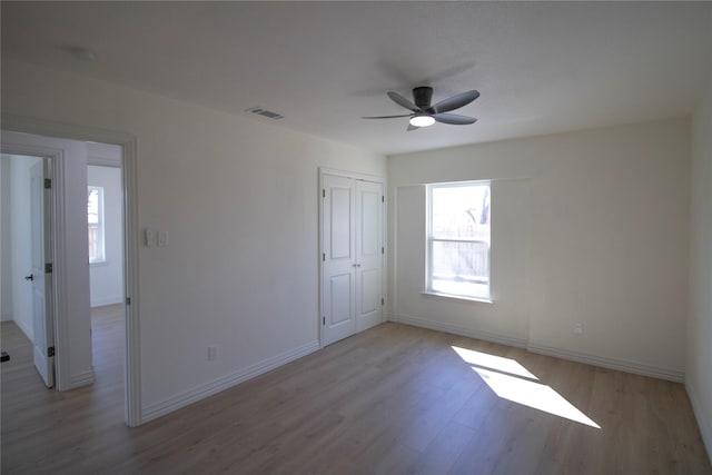 unfurnished bedroom with light wood-style flooring, baseboards, and visible vents