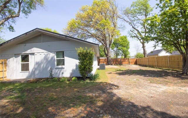 exterior space with central AC and a fenced backyard