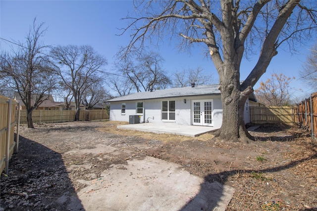 rear view of house featuring central air condition unit, french doors, a fenced backyard, and a patio