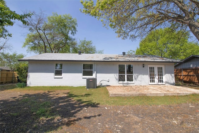 rear view of property with central air condition unit, a patio area, brick siding, french doors, and fence
