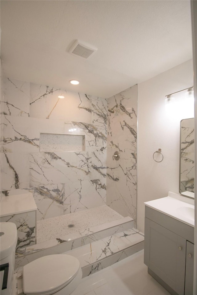 full bathroom featuring vanity, visible vents, a marble finish shower, toilet, and marble finish floor