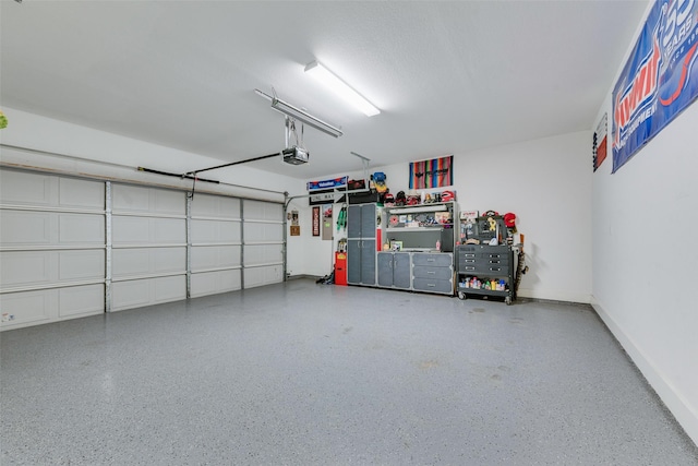 garage featuring a garage door opener and baseboards