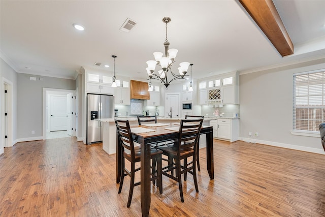 dining area with baseboards, light wood-style flooring, and ornamental molding