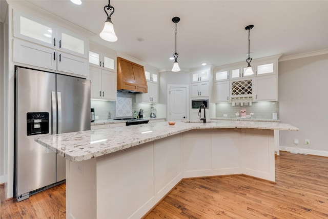 kitchen featuring premium range hood, stainless steel refrigerator with ice dispenser, light wood-style floors, white cabinets, and built in microwave