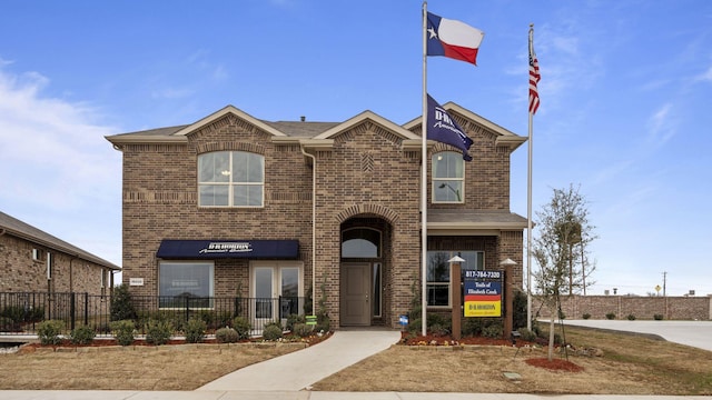 view of front of house featuring brick siding and fence