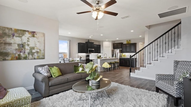 living area with visible vents, stairs, baseboards, and wood tiled floor