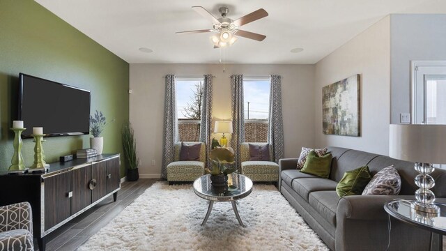 living room featuring baseboards, dark wood-type flooring, and ceiling fan