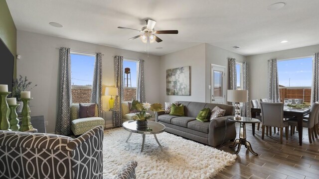 living room featuring dark wood-type flooring and a ceiling fan