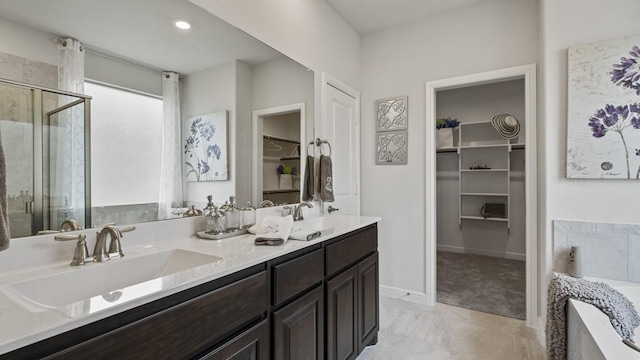 full bathroom with a stall shower, a walk in closet, and a sink