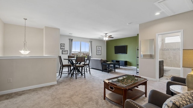 carpeted living room featuring baseboards and ceiling fan