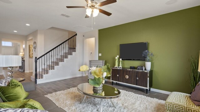 living room with visible vents, baseboards, and stairway