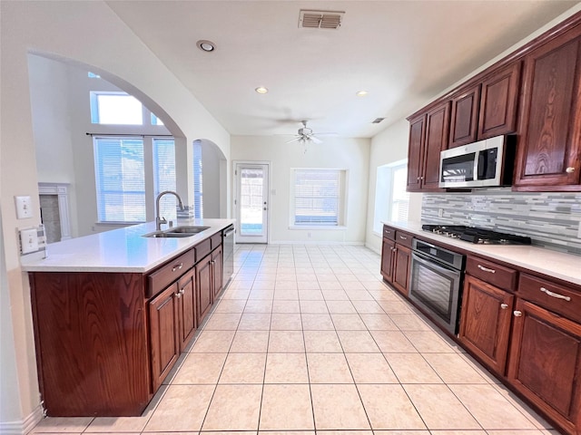 kitchen featuring a sink, light countertops, decorative backsplash, and stainless steel appliances