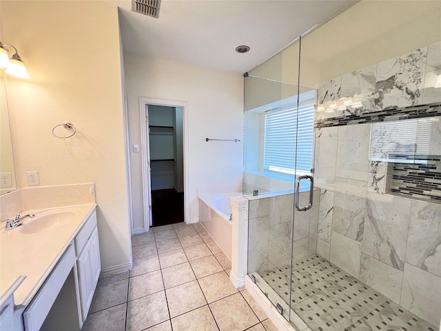 bathroom featuring tile patterned flooring, visible vents, a stall shower, a bath, and vanity