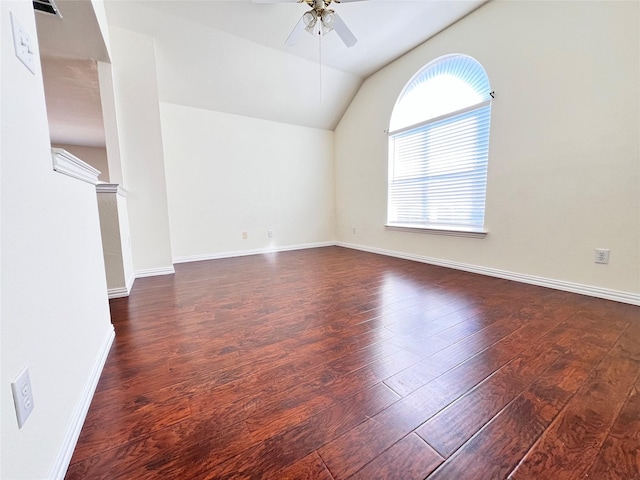 empty room featuring visible vents, wood finished floors, baseboards, ceiling fan, and vaulted ceiling