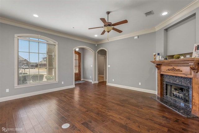 unfurnished living room featuring visible vents, ceiling fan, a fireplace, wood finished floors, and arched walkways