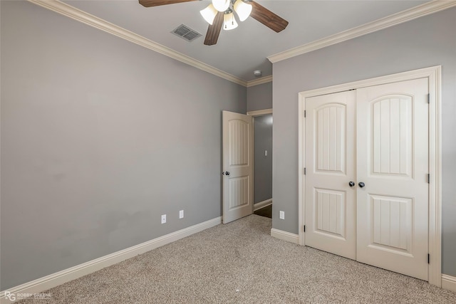 unfurnished bedroom with baseboards, visible vents, ornamental molding, a closet, and light colored carpet