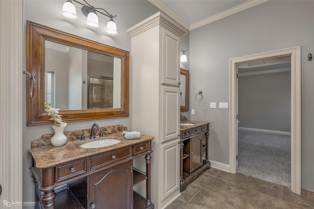 full bathroom with ornamental molding, two vanities, baseboards, and a sink