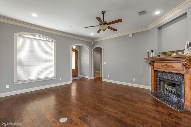 unfurnished living room featuring visible vents, hardwood / wood-style floors, a high end fireplace, arched walkways, and crown molding