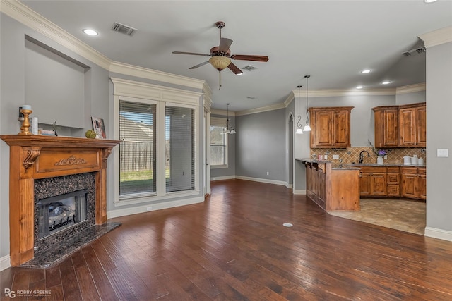 kitchen with visible vents, brown cabinets, a fireplace, and wood-type flooring