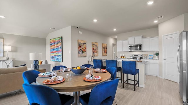 dining area featuring light wood finished floors, visible vents, and recessed lighting