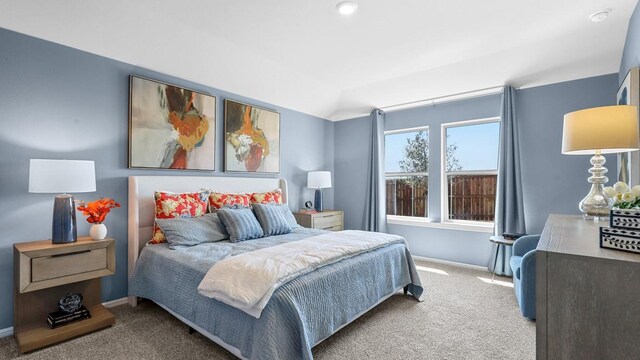 bedroom with vaulted ceiling, baseboards, and carpet floors