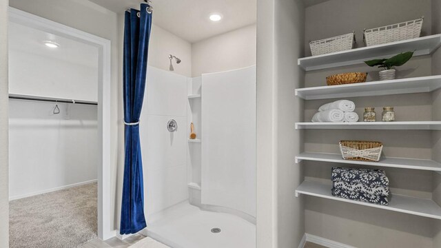 bathroom featuring a spacious closet, recessed lighting, a stall shower, and baseboards