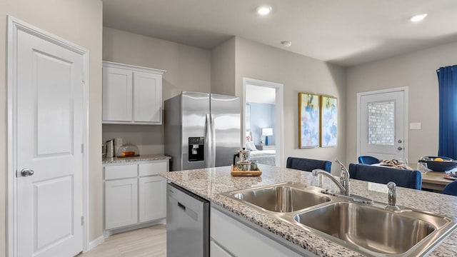 kitchen featuring light wood-style flooring, a sink, recessed lighting, appliances with stainless steel finishes, and white cabinets