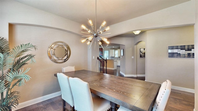 dining space with baseboards, arched walkways, a chandelier, and dark wood-style flooring