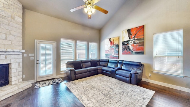 living room featuring baseboards, high vaulted ceiling, a fireplace, dark wood-style flooring, and ceiling fan