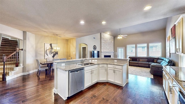 kitchen with open floor plan, dishwasher, dark wood-type flooring, and a sink