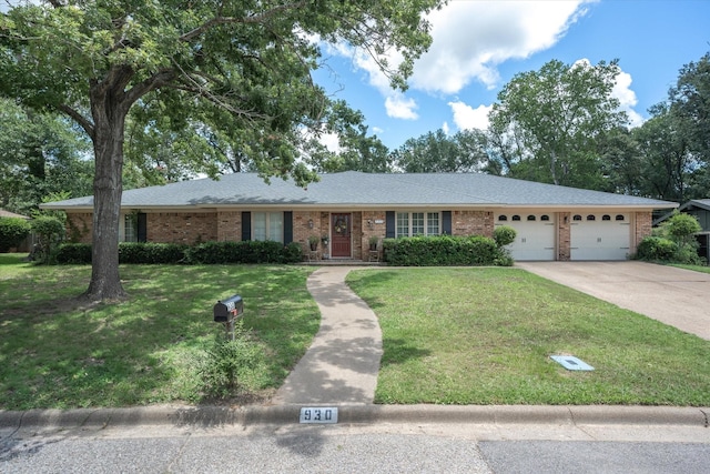 ranch-style house featuring driveway, a front yard, a shingled roof, a garage, and brick siding