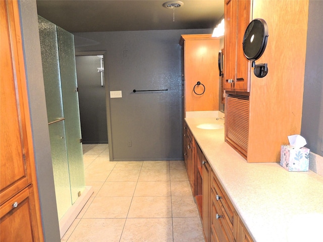 full bath with tile patterned floors, a stall shower, and vanity