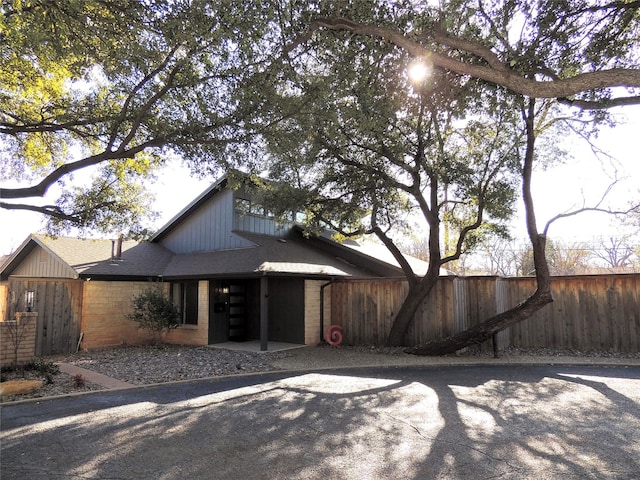 view of front of property featuring fence and roof with shingles