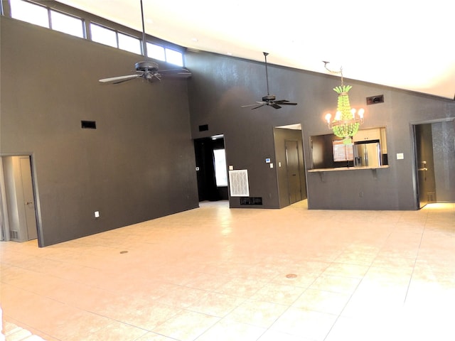 unfurnished living room featuring lofted ceiling, ceiling fan with notable chandelier, and visible vents