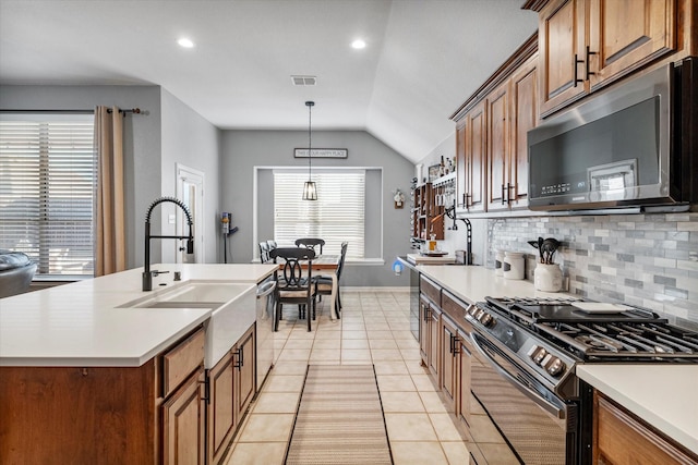 kitchen featuring visible vents, light tile patterned flooring, a sink, appliances with stainless steel finishes, and tasteful backsplash