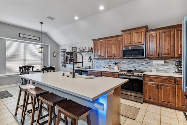 2604 Leisure Ln, Little Elm, TX 75068 - kitchen featuring appliances with stainless steel finishes, vaulted ceiling, light tile patterned floors, tasteful backsplash, and a kitchen bar