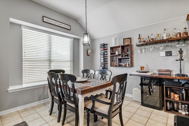 2604 Leisure Ln, Little Elm, TX 75068 - dining area featuring light tile patterned floors, vaulted ceiling, baseboards, and a dry bar