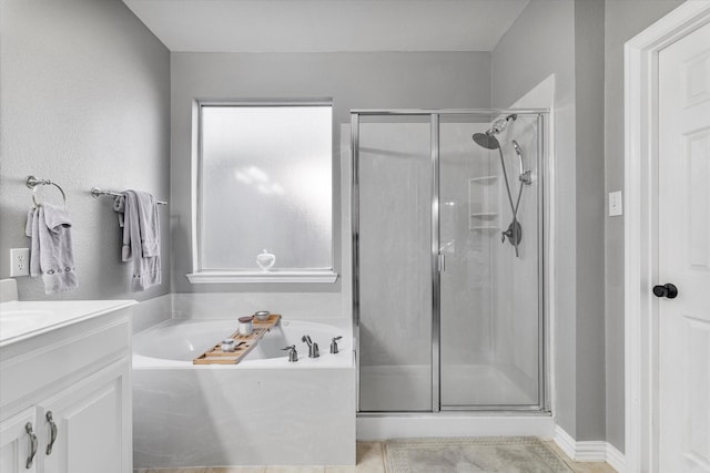 full bathroom with a garden tub, vanity, and a shower stall