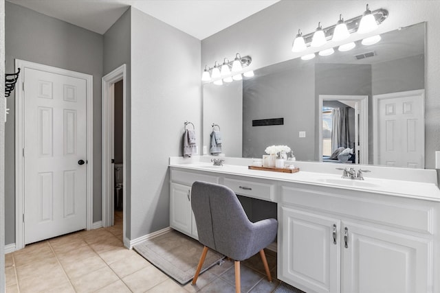 bathroom with a sink, visible vents, double vanity, and tile patterned flooring