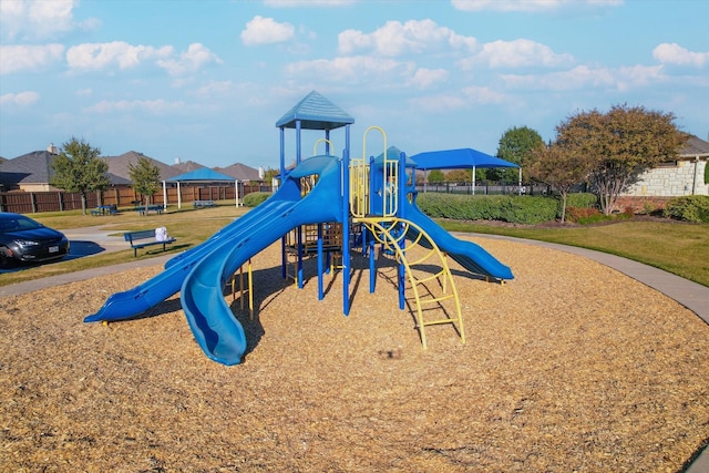 community play area with a yard and fence