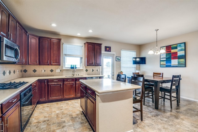 kitchen with stainless steel microwave, black oven, decorative backsplash, gas stovetop, and a sink