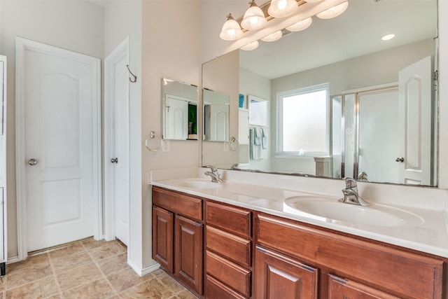 bathroom with double vanity, a stall shower, and a sink