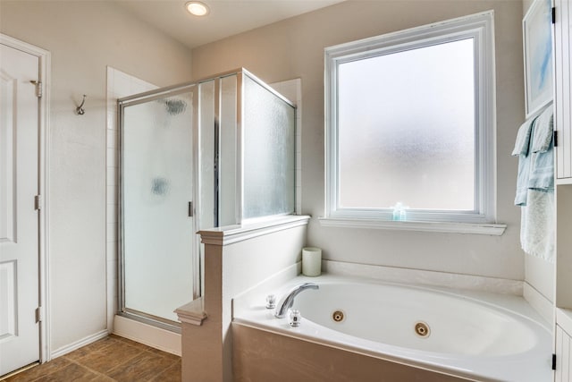 full bathroom featuring a tub with jets and a shower stall