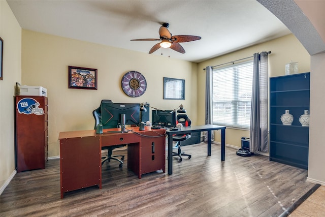 home office with a ceiling fan, wood finished floors, and baseboards