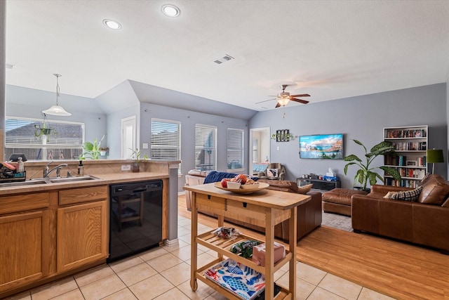 kitchen featuring brown cabinetry, black dishwasher, visible vents, and open floor plan