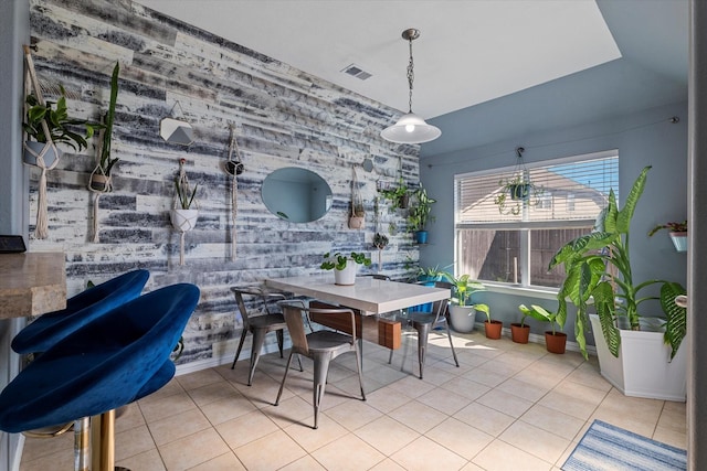 dining area with an accent wall, tile patterned floors, baseboards, and visible vents