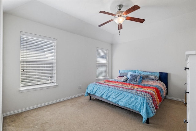 carpeted bedroom featuring a ceiling fan, lofted ceiling, and baseboards