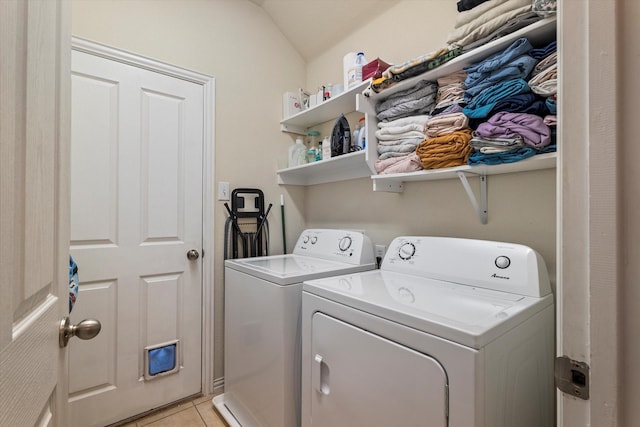 washroom with light tile patterned flooring, laundry area, and washing machine and clothes dryer